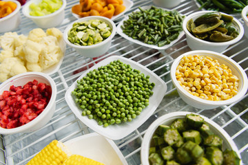 A variety of frozen foods lie in white cups.