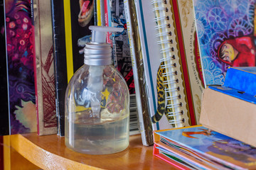 gel alcohol bottle among children's books