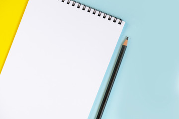 Paper notepad and pencil on the colorful background.