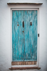Vintage Retro Entrance Facade with Blue Painted Wooden Door in Vejer de la Frontera, Cadiz, Spain