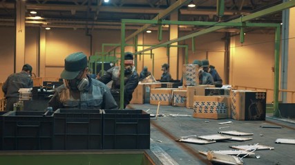 Factory workers are sorting boxes and broken electronics