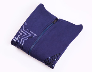 Blue folded zipped sweater decorated with sequins in star shape on white background. Clothes, fashion concept. Sportswear