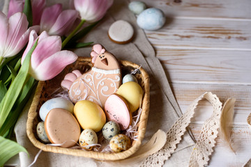Beautiful Easter composition of eggs with natural colors, gingerbread, flowers, feathers.