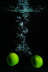 Green Lime in Water on Black Background