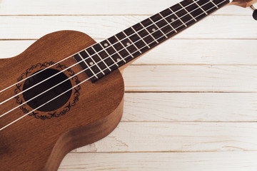 Fototapeta premium A ukulele with strings on white wooden background