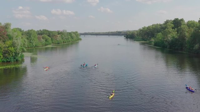 sunny summer day over green islands on a river in a northern city, people actively spend time on the river, kayaking and wake boarding, wake surfing after fast boats - Aerial Fligh