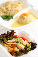 food delivery in white lunch boxes. Food to go. Caesar salad in box. Healthy food. 