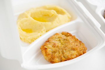 food delivery in white lunch boxes. Food to go. Mashed potatoes and chicken chop. 