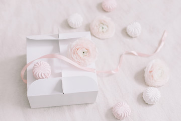 Gift or present box with pink ribbon and flowers on white background top view. Birthday or holiday background. pastel colors