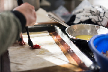 Hand preparing dough for baking with an egg wash