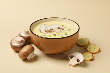 Mushroom cream soup on beige background, close up