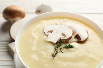 Mushroom cream soup on wooden background, close up