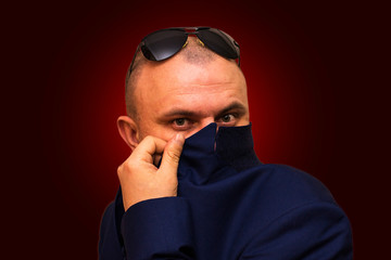 A man covers his face with a jacket.