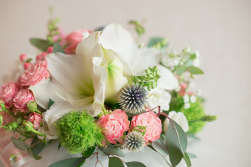 A large flower arrangement in a hat box was created by a florist for a wedding gift. Hydrangea, amarallis, roses and eucalyptus in a bouquet