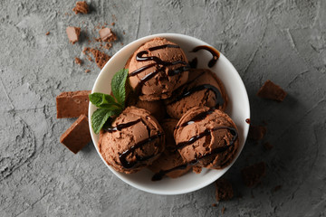 Bowl with ice cream on grey background, top view