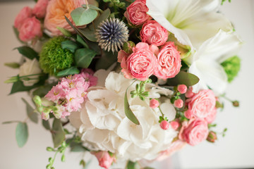A large flower arrangement in a hat box was created by a florist for a wedding gift. Hydrangea, amarallis, roses and eucalyptus in a bouquet