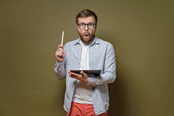 Great idea. Man with glasses, indicates stylus pen up, holds the tablet in hands and looks with an...