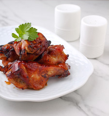 Baked chicken wings in soy sauce and honey, on a marble background