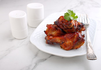 Baked chicken wings in soy sauce and honey, on a marble background