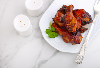 Baked chicken wings in soy sauce and honey, on a marble background, top view
