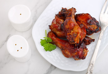 Baked chicken wings in soy sauce and honey, on a marble background, top view