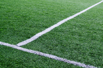 Obraz premium white stripes of marking on a green soccer field