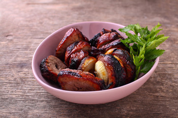 Grilled meat pieces in a plate on a dark background