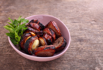Grilled meat pieces in a plate on a dark background