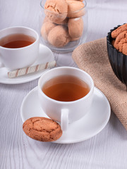 Two cups of tea with biscuit