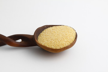dry bulgur wheat in wooden spoon isolated on white background. top view
