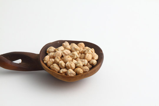 Chickpeas or Turkish peas in a wooden spoon on a white background