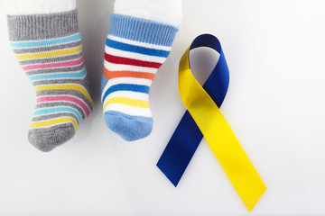 World Down syndrome day background. Down syndrome awareness concept. Socks and ribbon on white...