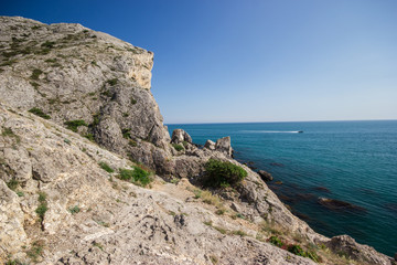 Fototapeta na wymiar Seascape rocky terrain with boat on the waves