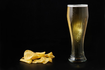 Cold light beer in glass and chips