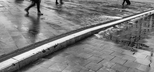 Vista urbana de una calle de Bruselas en invierno con gente pasando por un bordillo pintado de...