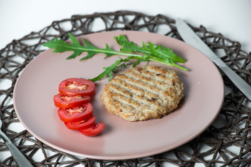 juicy fried meat cutlet with tomato on a plate