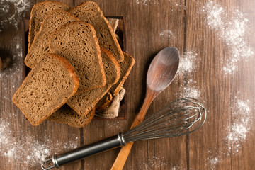 Fototapeta na wymiar Slices of brown bread with wooden spoon