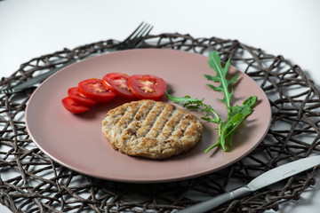 juicy fried meat cutlet with tomato on a plate