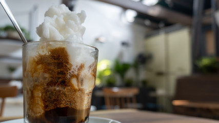 Ice coffee with ice cream on a wooden table, Hanoi, Vietnam.