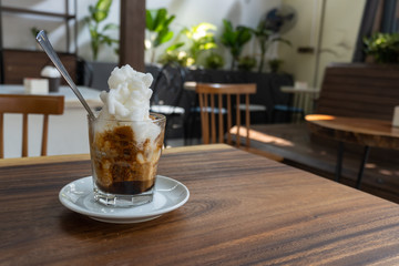 Ice coffee with ice cream on a wooden table