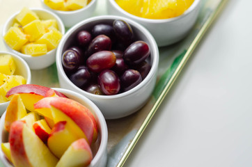 Various set fruits, pineapple, apple, grapes with matured cheddar cheese in bowls