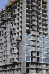 High-rise building under construction. Reinforced concrete frame. Start of installation of double-glazed windows.