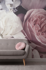 Fototapeta na wymiar Modern sofa near wall with floral wallpaper. Stylish living room interior