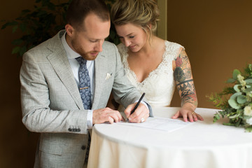 Bride and groom signing marriage certificate