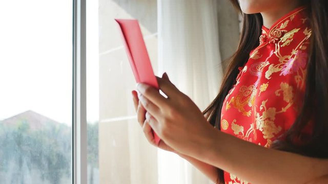 An Asian woman in a red cheongsam Expressed the joy of receiving an envelope from the Chinese New Year.