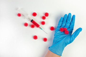 Doctor's hand in sterile gloves holding a mockup of virus of COVID-19 novel coronavirus as dangerous flu strain cases as a pandemic. World epidemia concept