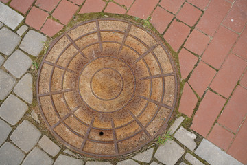 Manhole cover. old brown rusty sewer cover with nobody. top view.