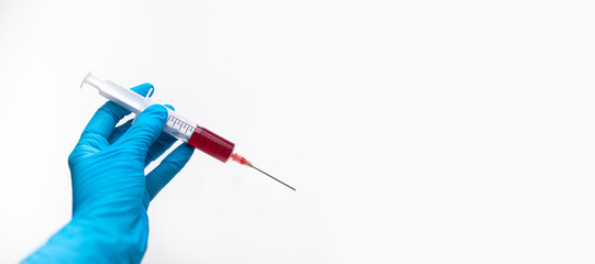 Hand hält mit Blut gefüllte Spritze