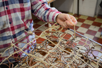 Upholstery springs. Upholstery worker tying old srpings. Upholstery workshop. Old chair springs...