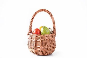 Vintage wicker basket with easter eggs isolated on white background